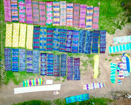 Aerial view of vibrant textiles laid out in neat rows, creating a colorful mosaic on the ground, Ede, Osun, Nigeria.