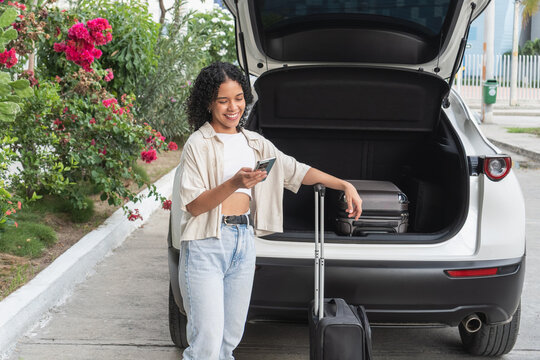 Woman smiling checking phone preparing for road trip