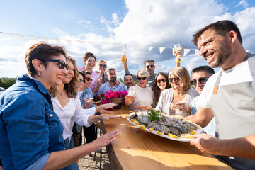 Friends enjoying outdoor oyster bar sharing food