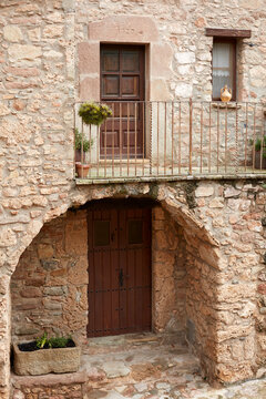 Rustic stone facade with wooden doors and balcony