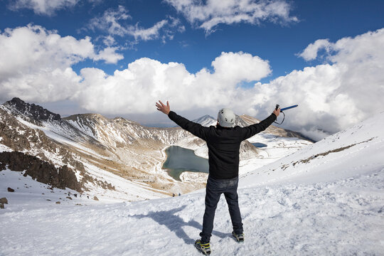 Adventurer embracing winter mountain view with joy