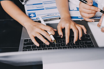 Group of doctors attending seminar in hospital lecture hall with senior physician giving medical...
