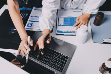 Group of doctors attending seminar in hospital lecture hall with senior physician giving medical...