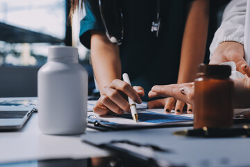 Group of doctors attending seminar in hospital lecture hall with senior physician giving medical...