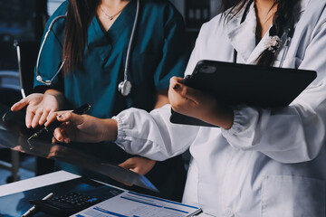 Group of doctors attending seminar in hospital lecture hall with senior physician giving medical...