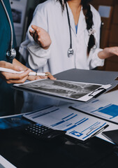 Group of doctors attending seminar in hospital lecture hall with senior physician giving medical...
