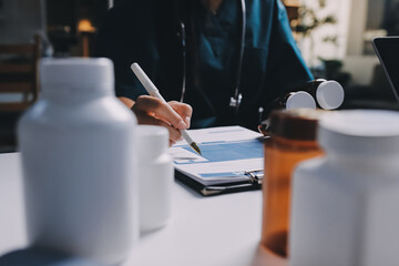 Group of doctors attending seminar in hospital lecture hall with senior physician giving medical...