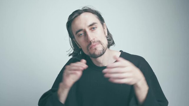 Applause: Calm Male Speaker in Soft Lighting Reflecting Deep Thoughts with Gestures in a Neutral Background