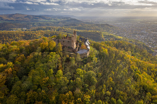 Aerial view of Auerbach castle ruin perched atop a hill, surrounded by a forest ablaze with autumnal colors, Bensheim, Hessen, Germany.