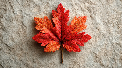 Red autumn leaf on textured stone background with warm feeling