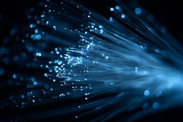 Fiber optic strands emit vibrant blue light, creating an enchanting scene in a dark setting. The dense arrangement of cables highlights the beauty of technology and illumination