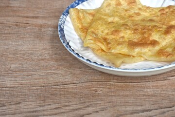fried roti southern flat bread on white paper tray in plate