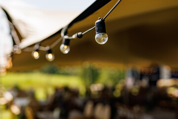 Outdoor string lights under tent roof © 9parusnikov