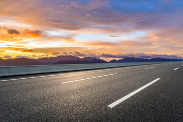 Asphalt highway road and mountain with beautiful sky clouds at sunset