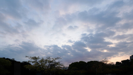 Obraz premium Golden sunset sky over urban cityscape with glowing evening horizon