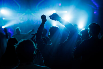 People dancing at concert with blue lights