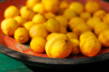 Fresh yellow lemons in rustic bowl