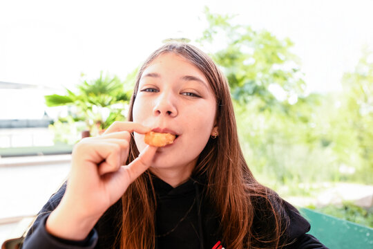 Teenager enjoying a nugget meal at a fast food restaurant.