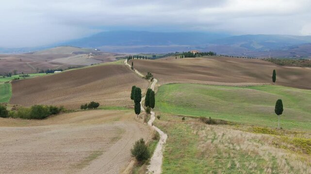 Zoom Out Aerial View of Gladiator Road in Toscana. Gliding to a Landscape of Golden Hills and Cypresses. Drone Shot