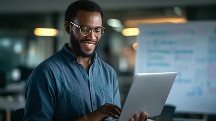 A smiling African American IT expert codes machine learning algorithms in a startup office reviewing code on a laptop a whiteboard with bug fixes AI code review startup tech