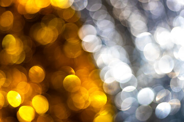 Golden and silver bokeh background with soft circular light reflections creating a luxurious and festive texture. Ideal for elegant holiday design, celebration, glamour photo, modern artistic concepts