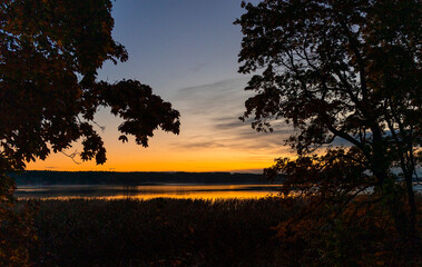 Beautiful autumn morning landscape of a lake before the runrise. Seasonal scenery in Riga, Latvia.