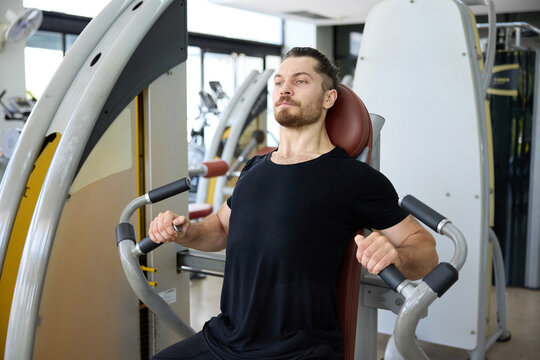 Young man doing chest press in the gym