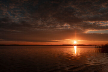 A beautiful autumn scenery of a lake right after the sunrise. Vibrant sky reflections ir Riga, Latvia.
