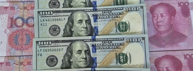 100 yuan banknote among 100 US dollar banknotes