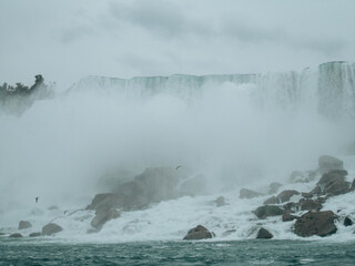 A close-up view of Niagara Falls on a foggy day with mist covering the waterfall