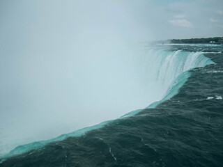A close-up view of Niagara Falls on a foggy day with mist covering the waterfall