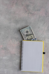 A notebook with dollars on the table on the left side, with space for text