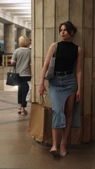 Beautiful brunette stands at the metro station waiting for the train to arrive
