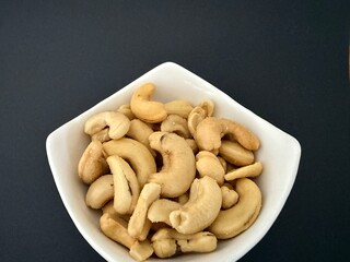 Close-up of dried cashews in a white bowl. Healthy, natural food.
