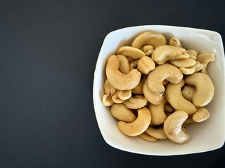 Close-up of dried cashews in a white bowl. Healthy, natural food.
