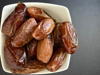 Close-up of dried dates in a white bowl. Healthy, natural food.