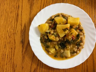 Stew with potatoes, white beans, tomatoes, and celery. Delicious home cooking.