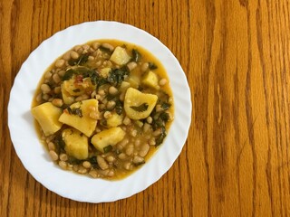 Stew with potatoes, white beans, tomatoes, and celery. Delicious home cooking.