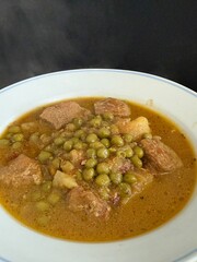 Braised potatoes with green peas and meat. Delicious home cooking.