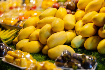 Fresh and ripe mangoes displayed at a vibrant Thai street market stall