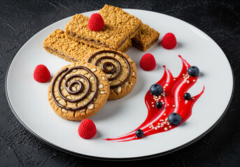 Sweet cookies with raspberries and blueberries on a white plate