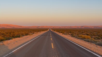 Evening descends as a desert road winds through golden dunes and sparse greenery, serene journey through tranquil twilight
