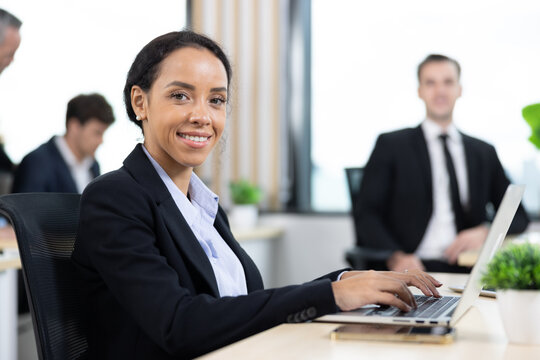 African american business woman working with laptop in modern meeting room. Multi-Ethnic Corporate Business Meeting. Female executive handling real estate project. Financial analysis. - Powered by Adobe