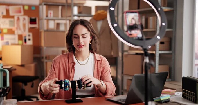 Ring light, video and woman with jewelry, startup and live streaming with smartphone on social media. Entrepreneur, digital marketing or person with bracelets in warehouse, mobile and brand awareness