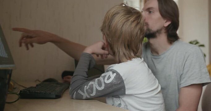 Man Teaches Kid Boy to Play Chess on Computer. 4K 10-bit