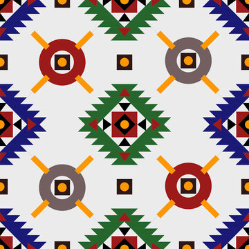 ชื่อผลงาน: Seamless geometric tribal pattern inspired by native ethnic designs, displayed on a rustic wooden background. Colorful symmetrical shapes with traditional motifs perfect for textile prints,