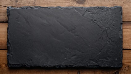 Black slate stone resting on a wood surface, ideal for culinary presentations