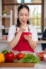 Asian woman tasting fresh cherry tomato during cooking