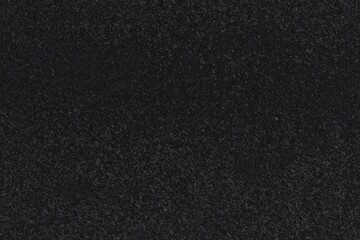 Fototapeta premium Textured black surface. Dark, slightly grainy appearance with subtle variations in tone. Uniform distribution of minuscule speckles