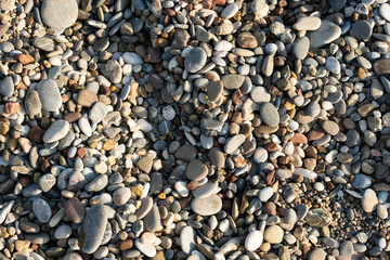 Close-Up Of Smooth Multicolored Pebbles On A Pebble Beach Surface With Natural Texture